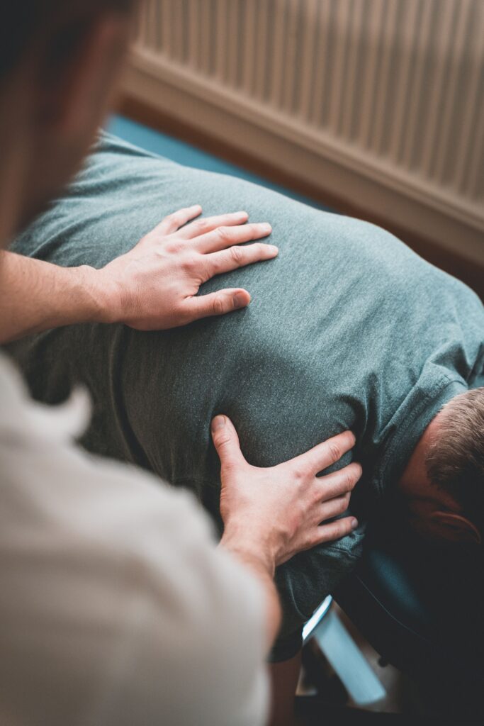 Osteopath treating patient on treatment table - conditions treated by an osteopath.